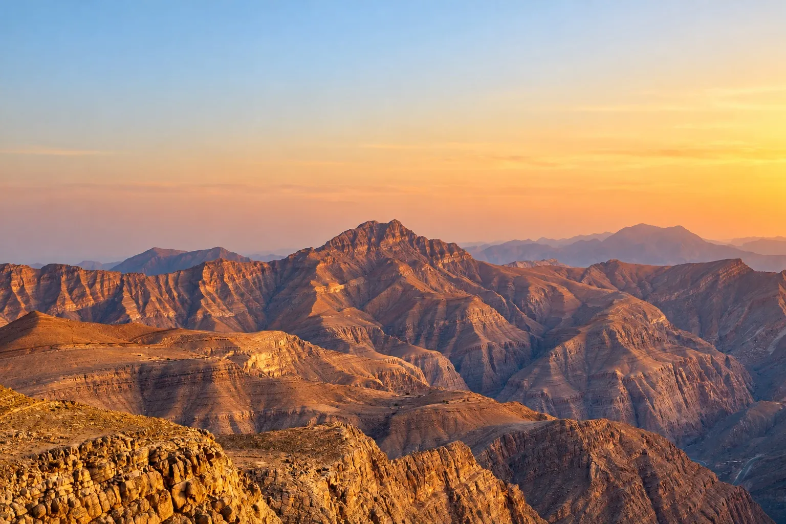 The Hajar Mountains in Ras Al Khaimah glowing in warm sunrise light.