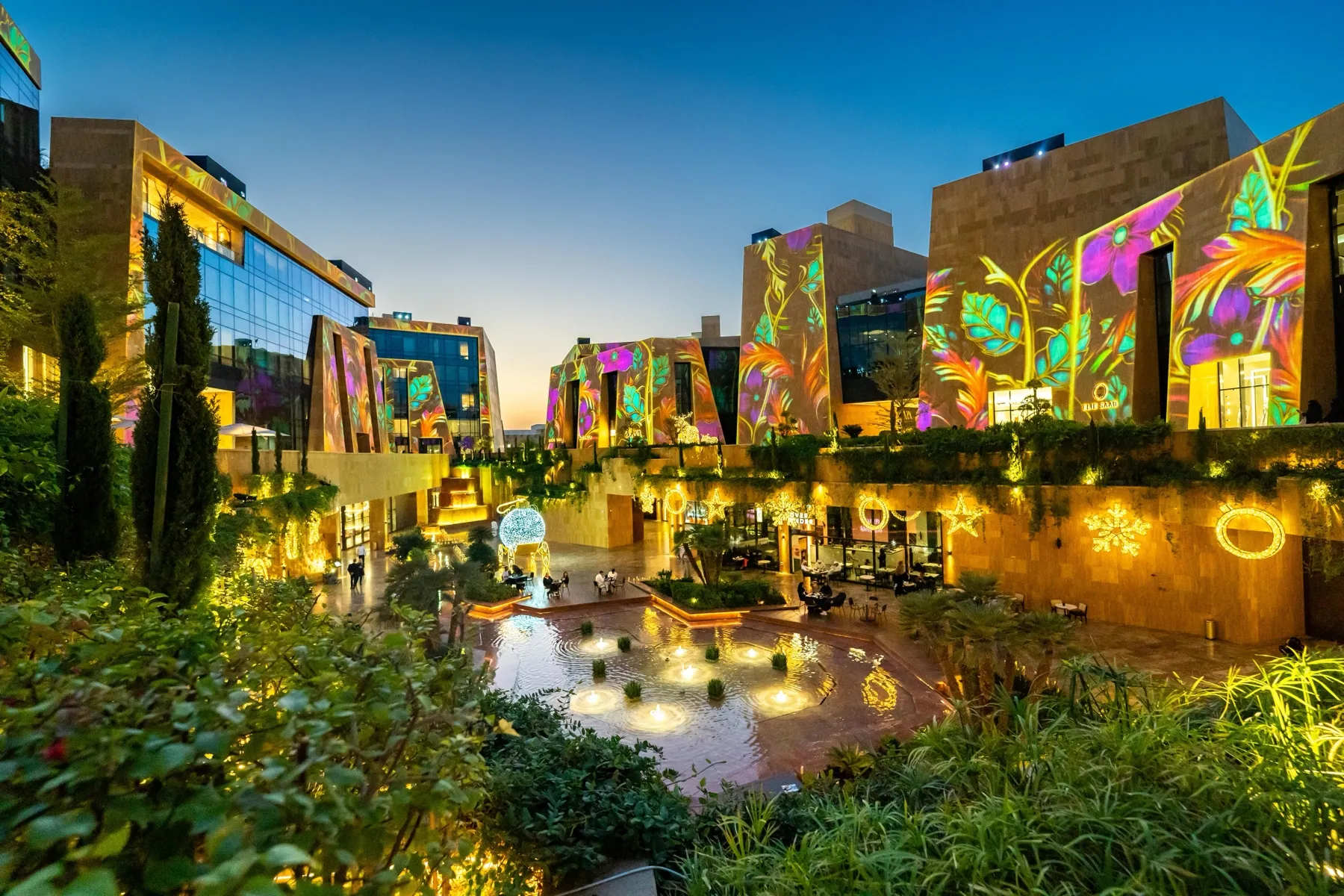 VIA Riyadh's stone façades are covered in colourful floral projections above landscaped courtyards