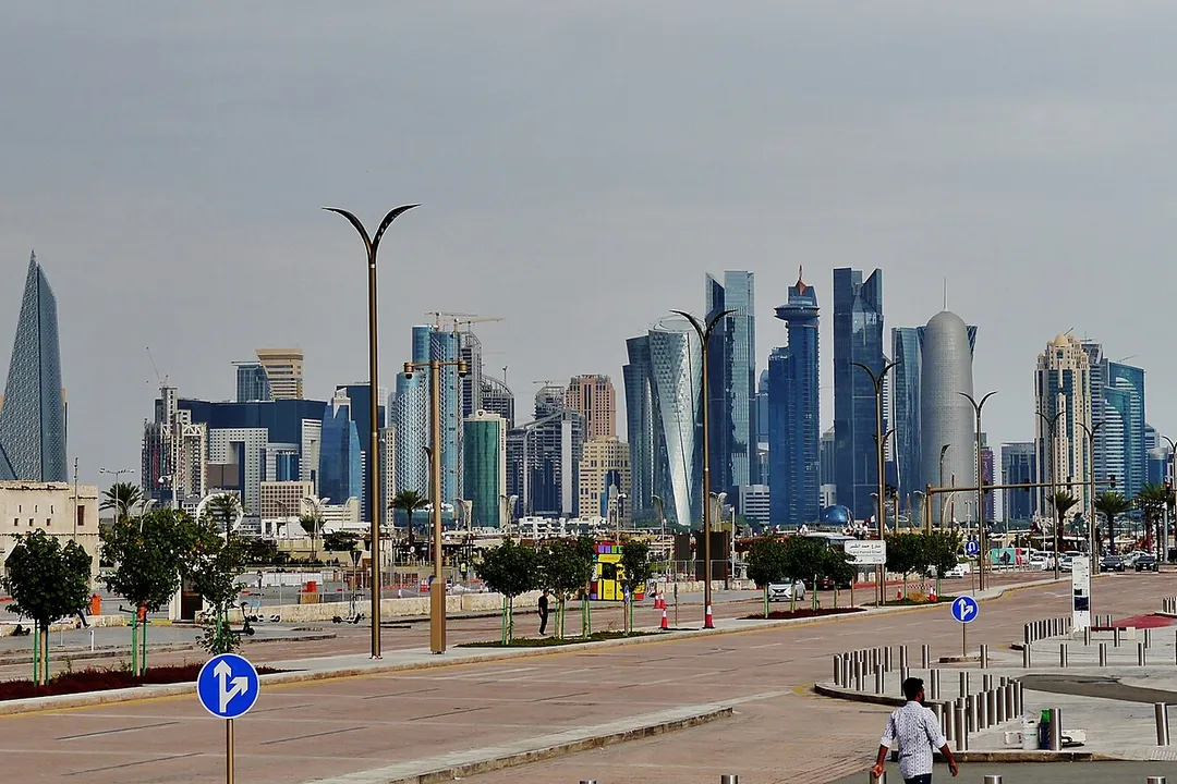 Doha’s West Bay skyline beyond a broad city road, photographed from the Corniche area.